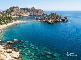 A stunning aerial view of a picturesque coastline with crystal-clear waters and lush greenery, perfect for exploring by boat or enjoying a relaxing day at the beach.