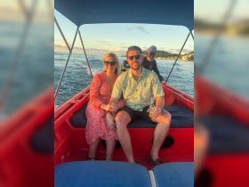A couple enjoys a scenic boat ride at sunset, capturing a moment of joy and relaxation on the water.