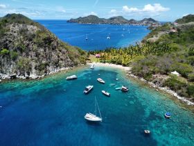 A stunning aerial view of a serene bay surrounded by lush greenery and crystal-clear waters, showcasing a perfect tropical getaway.