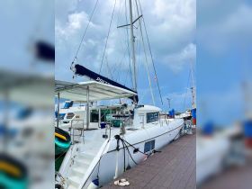 A sleek catamaran docked at the marina, showcasing its elegant design and spacious deck, perfect for sailing adventures.