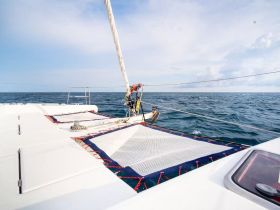 A close-up view of a catamaran's deck, showcasing its sleek design as it sails through open waters — perfect for adventure seekers and sailing enthusiasts.
