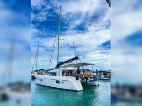 A catamaran docked at a marina, showcasing its sleek design and crew members preparing for the next adventure on the water.