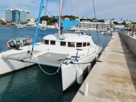 A beautiful catamaran docked at the marina, showcasing its sleek design and vibrant sails, perfect for sailing adventures.