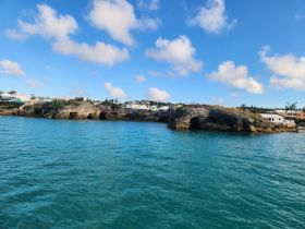 A stunning view of the rocky coastline and colorful homes of Bermuda, showcasing the natural beauty and vibrant architecture of the island.