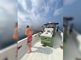 A group of friends enjoys a fishing trip on a boat, casting lines into the calm ocean waters — perfect for a day of adventure and relaxation.