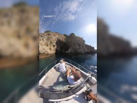 A couple enjoys a scenic boat ride, taking in the stunning views of a coastal cave — perfect for exploration and adventure on the water.
