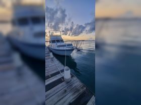 A serene view of a yacht docked at sunset, showcasing the tranquil waters and beautiful sky — perfect for evening cruises or relaxation by the marina.