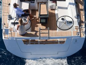 A couple enjoys the helm of a sleek yacht, showcasing the modern interior design and comfortable seating, perfect for navigating the open waters.