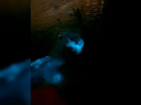 An unclear image depicting glowing elements in water, possibly bioluminescence, but lacks clarity and identifiable subjects.