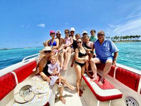 A joyful group of family and friends enjoys a sunny day on the water, capturing memories aboard their boat — perfect for family outings and celebrations.