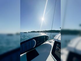A paddleboard rests on the deck of a boat under bright sunshine, showcasing the perfect setup for a day of water activities.