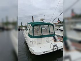 A well-maintained boat named 'Pipe Dreams' docked at a marina, showcasing its sleek design and green canopy.