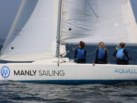 A group of sailors enjoy a day on the water aboard a sailing vessel, showcasing the thrill of sailing and camaraderie on the open sea.