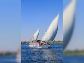 A stunning sailboat glides through the water, showcasing its elegant sails against a clear blue sky — perfect for leisurely cruises.