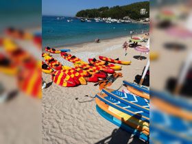 A vibrant display of kayaks and paddleboards on the beach, ready for water adventures. Enjoy a day of fun in the sun with these exciting water toys.