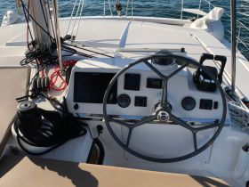A detailed view of the helm and console area on a yacht, showcasing the steering wheel and navigation equipment, perfect for those interested in boating interiors.