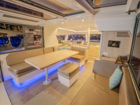A stylish interior view of a boat's cabin featuring a spacious dining area and comfortable seating, perfect for relaxing and enjoying meals on the water.