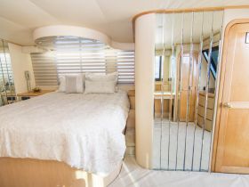 A cozy and elegantly designed cabin interior featuring a comfortable bed and stylish decor, perfect for relaxing on a yacht.