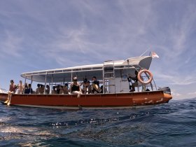 A lively group of guests aboard a snorkeling boat, enjoying the ocean and preparing for an underwater adventure.