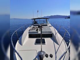A stunning view of a yacht cruising through calm waters, showcasing its sleek design and inviting deck space — perfect for a day on the water.