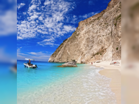 A stunning beach scene featuring a boat anchored in crystal-clear waters, with a picturesque cliff backdrop — perfect for a day of relaxation and exploration.