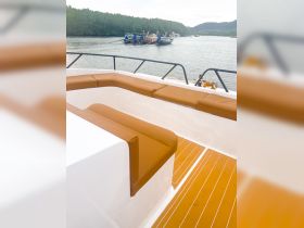A cozy seating area inside a boat, showcasing comfortable cushions and stylish flooring — perfect for relaxing during a day on the water.