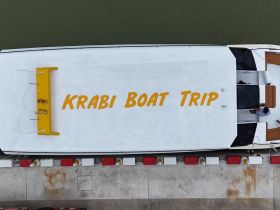 Aerial view of a boat named 'Krabi Boat Trip' docked at the marina, showcasing its sleek design and readiness for adventure.