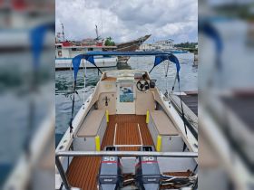 Interior view of a well-equipped boat featuring comfortable seating and a helm, perfect for day trips and water adventures.