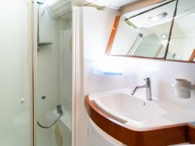 A clean and modern boat bathroom featuring a shower and sink, perfect for onboard comfort during your nautical adventures.