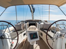 A beautifully designed interior of a sailing yacht featuring a helm and comfortable seating, perfect for relaxing while navigating the open waters.