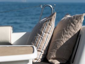 Cozy seating area on a boat featuring stylish cushions, perfect for relaxing while enjoying the open water.