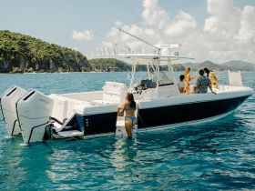 A lively group enjoys a day on the water, with some swimming and others relaxing on the boat, creating the perfect atmosphere for summer fun and adventure.