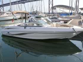 A sleek Chaparral speedboat docked in a marina, showcasing its elegant design and pristine condition — perfect for a day on the water.