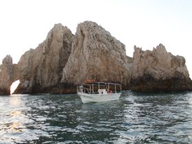 A scenic view of a boat navigating near stunning rock formations, showcasing the natural beauty of the coastline — perfect for sightseeing adventures.