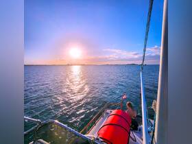 A serene sunset view from a boat, with a guest enjoying the peaceful waters — an ideal setting for relaxation and scenic cruises.