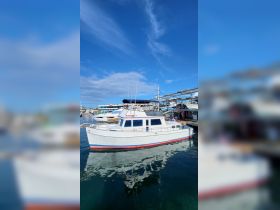 A picturesque view of a boat docked at the marina, showcasing its classic design against a clear blue sky — perfect for boat enthusiasts and charter opportunities.