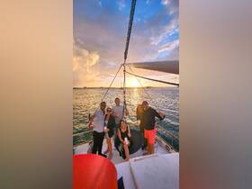 A lively group enjoys a sunset sailing experience, raising their glasses in celebration aboard a yacht — perfect for unforgettable gatherings on the water.