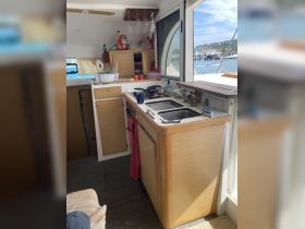 A well-equipped kitchen area inside a boat, featuring a sink, stove, and storage, perfect for preparing meals while enjoying life on the water.