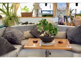 Cozy interior of a boat featuring a comfortable lounge area with plants and decorative elements, perfect for relaxing while on the water.