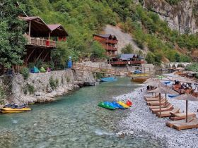 A scenic view of a riverside area with various boats and lounging spots, showcasing a relaxing atmosphere for visitors.