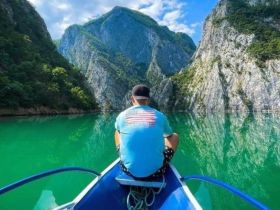A serene moment captured as a person enjoys the stunning mountain reflections on the tranquil waters, perfect for nature lovers and adventure seekers.