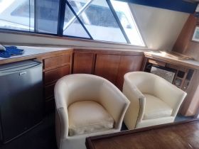 A cozy interior view of a boat cabin featuring comfortable seating and a well-equipped space, perfect for relaxing during your nautical adventures.