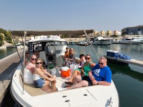 A lively group enjoys their time aboard a rental boat, capturing the essence of fun and relaxation on the water with drinks and good company.