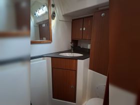 Interior view of a boat's bathroom area featuring a sink and storage cabinets, showcasing the functional design of onboard facilities.