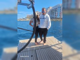 A couple enjoys a moment together on the deck of a boat, surrounded by beautiful water and scenic views — perfect for romantic outings or celebrations.