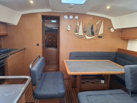 A cozy interior view of a yacht's cabin featuring comfortable seating and a dining area, perfect for relaxing and enjoying meals while on the water.
