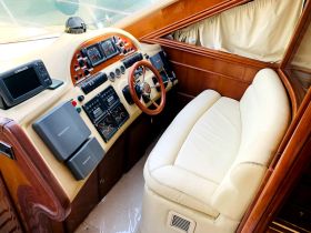 A well-appointed helm area showcasing the control console and seating of a luxury boat, perfect for navigating the open waters.