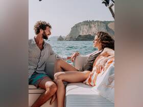 A couple enjoys a relaxing moment on a boat, surrounded by stunning ocean views — perfect for romantic getaways or leisurely days on the water.