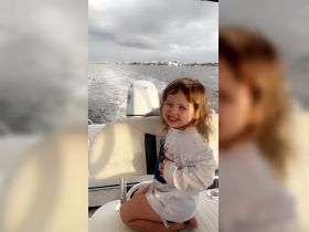 A joyful child smiles while sitting on a boat, capturing the essence of fun family outings on the water.