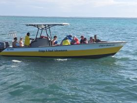 A lively group enjoys a boat adventure on the water, showcasing the fun and excitement of exploring with Ridge & Reef Adventures.